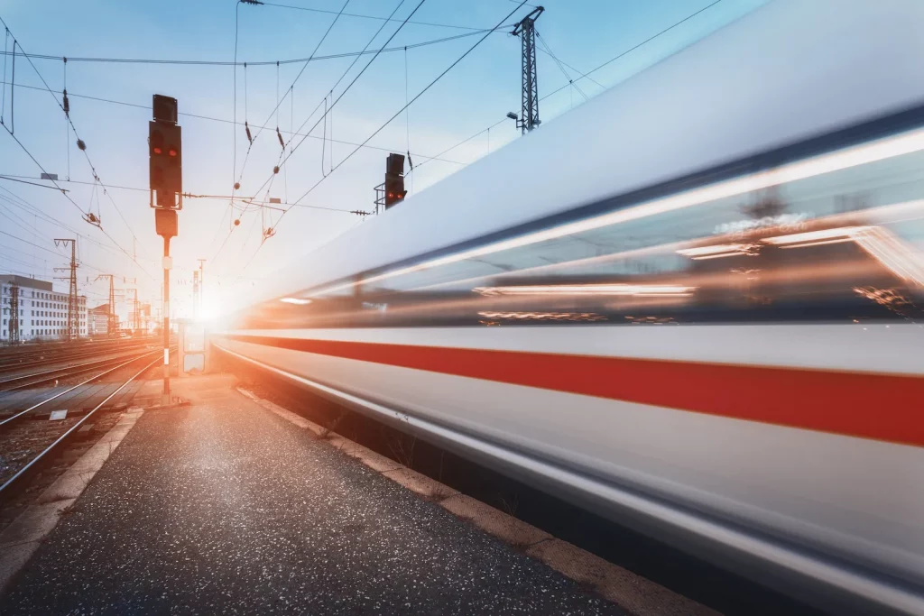 High-speed train passing railway signals and overhead lines